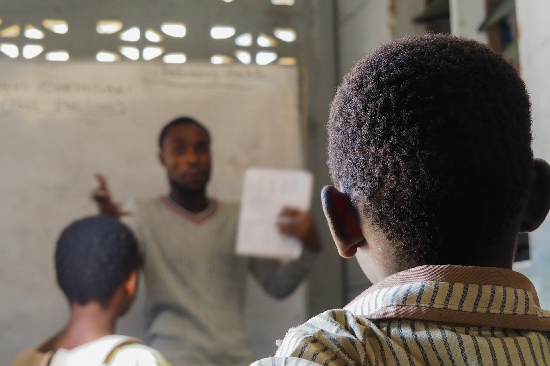 A teacher explaining a worksheet to students in a classroom