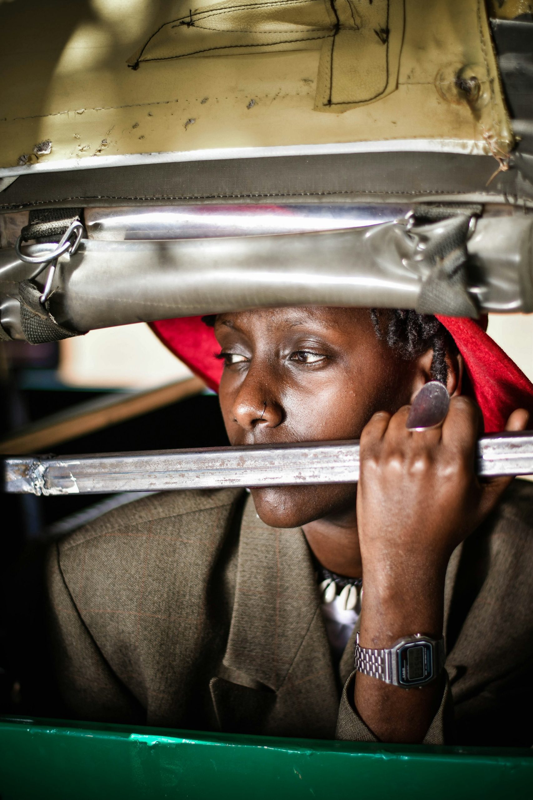 A young woman in a welding helmet holding a steel bar